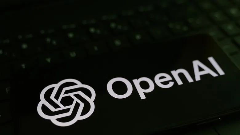 Логотип OpenAI на экране смартфона на фоне названия компании