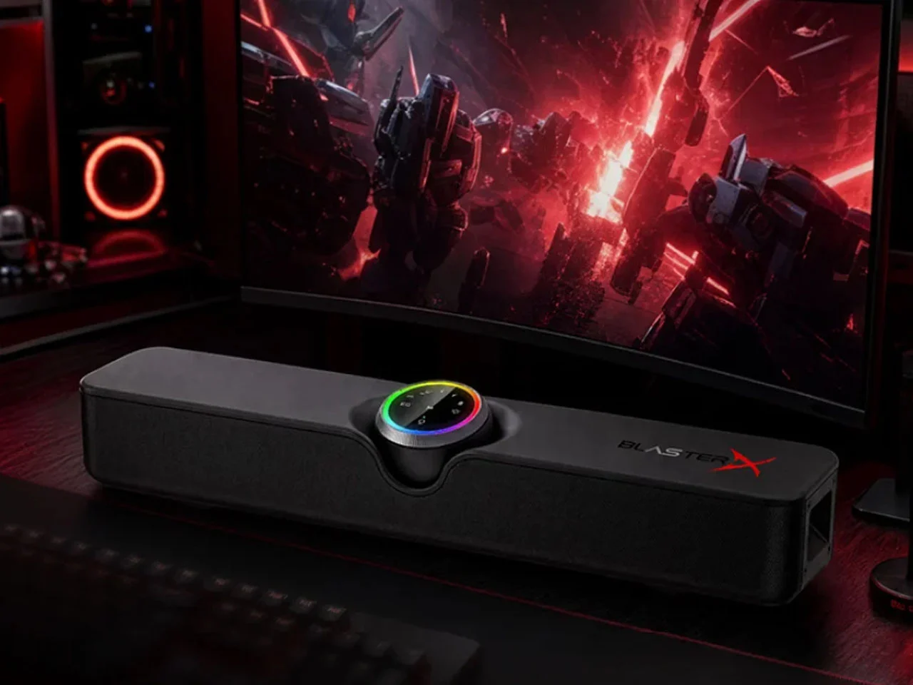 Саундбар Creative B3 с RGB-подсветкой на тёмном столе перед изогнутым игровым монитором