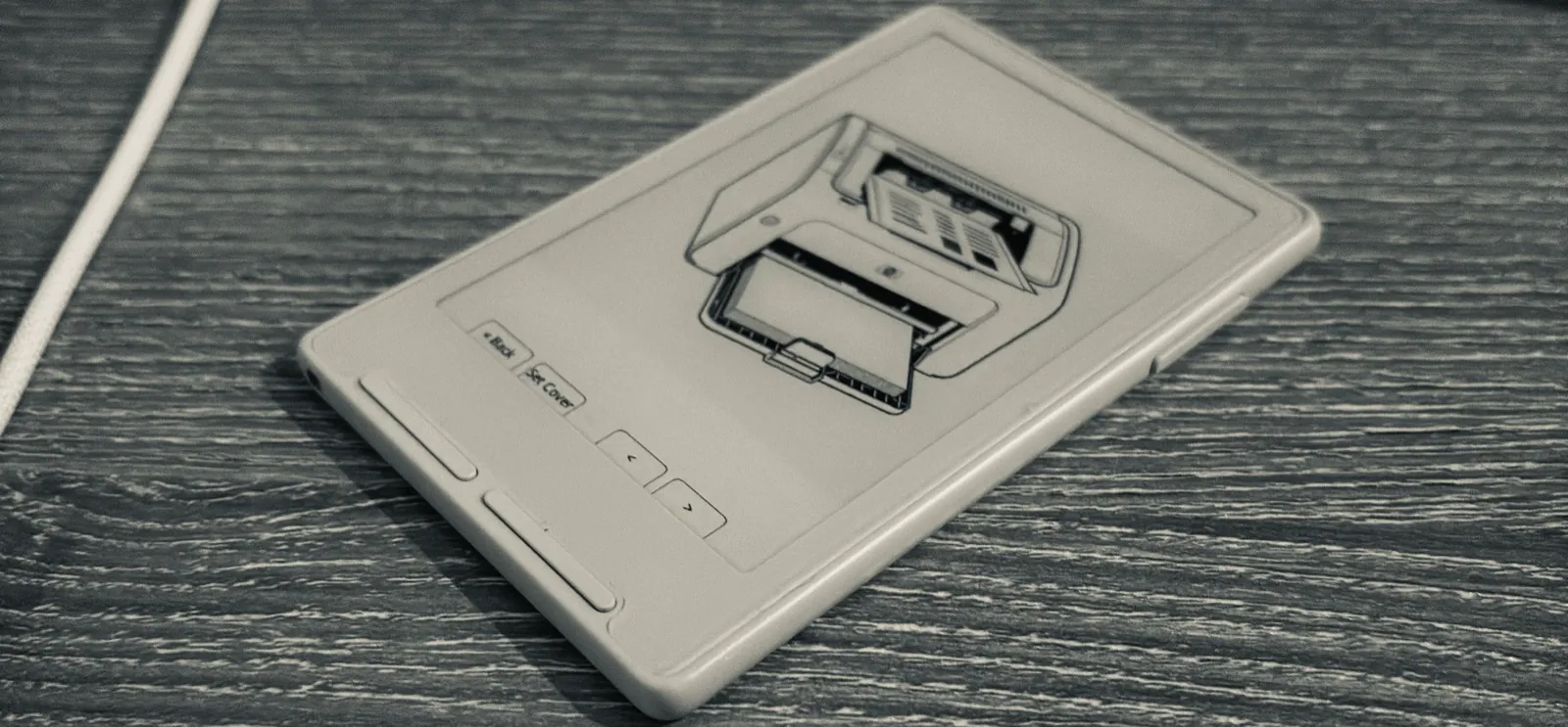 Компактный ридер Xteink с экраном E-ink, на который выведен документ